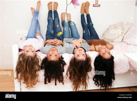 Girls Lying Upside Down On Bed Looking At Camera Stock Photo Alamy
