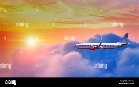 Airplane Flying Above Clouds In Sunset Light Stock Photo Alamy