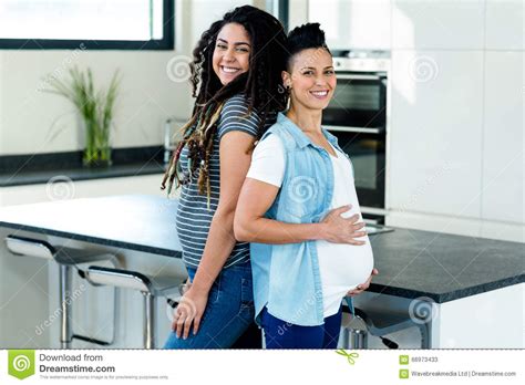 Pregnant Lesbian Couple Standing Back To Back Stock Image
