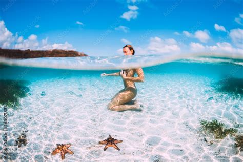 Naked Woman Swim In Blue Ocean With Starfish Underwater In Tropical