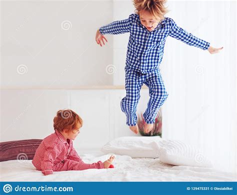 Defocused Excited Kids Brothers Playing In Bedroom Jumping On Bed In