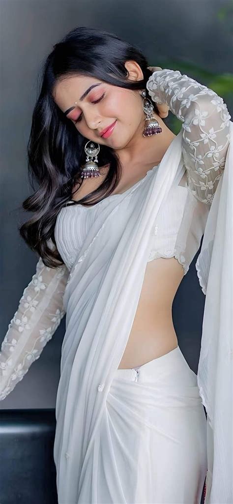 A Woman In A White Sari With Her Hands On Her Hips
