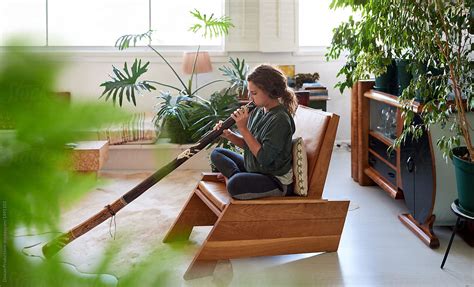 Woman Playing The Didgeridoo At Home By Stocksy Contributor Daxiao Productions Stocksy