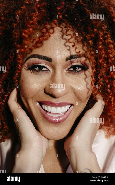 Portrait Of A Stylish Beautiful African American Woman With Curly Red Hair And Makeup Stock