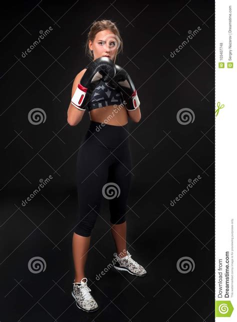 Beautiful Female Athlete In Boxing Gloves In The Studio On A Black