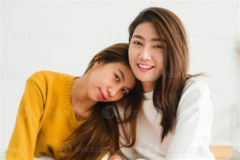 hermosas mujeres asiáticas jóvenes lesbianas lgbt pareja feliz sentada en la cama abrazándose y
