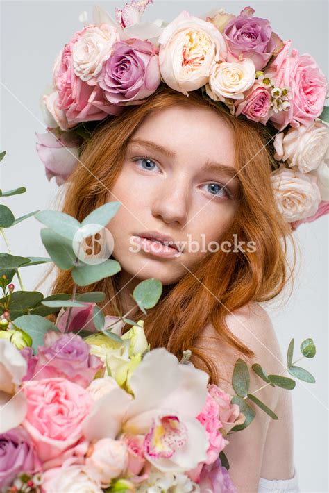 Close Up Portrait Of Stunning Young Woman With Red Hair And Floral Wreath Over White Background