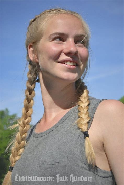 A Woman With Long Blonde Hair Wearing A Gray Tank Top And Braided Pigtails