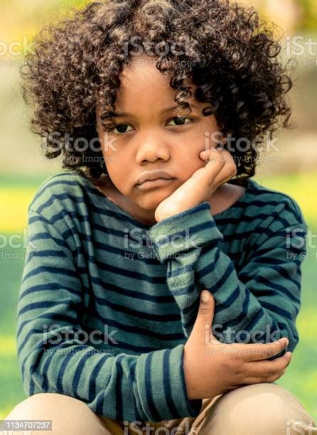 불행 한 지루한 작은 아프리카계 미국인 아이 공원에 앉아 부정적인 감정을 보여주는 소년 어린이 문제 개념입니다 아이에 대한 스톡