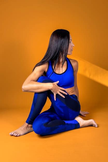 Premium Photo Seated Female Yoga Instructor Performing Stretches
