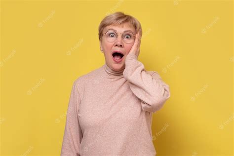 premium photo amazed mature woman in glasses with opened mouth feels stunned after shocking new