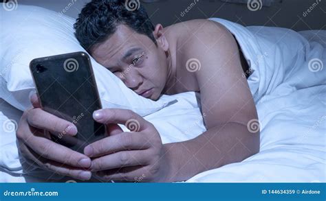 Phone Addicted Man Using Smart Phone On Bed At Midnight Stock Image