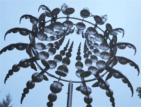 The Top Of A Metal Sculpture With Lots Of Leaves On It
