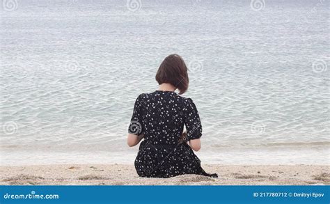 Woman Sitting On The Beach Back View Of Woman In Dress Sitting On The