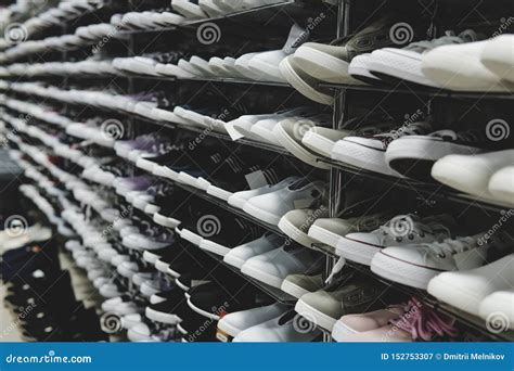 Side View Of Shoe Store Shelves With Of Lots Of Sneakers On Sale Low
