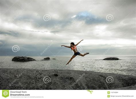 Woman Jumping On A Rock At Sunset On Bakovern Beach Cape Town Stock Photo Image Of Bakoven