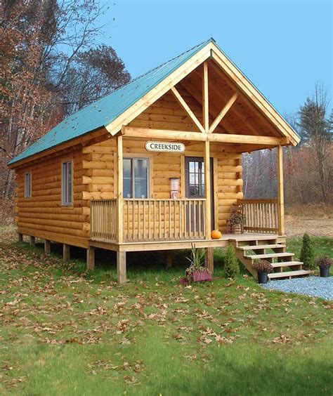 A Small Log Cabin Sits In The Middle Of A Grassy Area With Steps