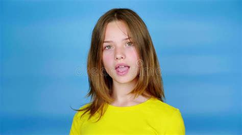 Teen Girl In A Yellow T Shirt Is Looking To The Camera Nods Her Head