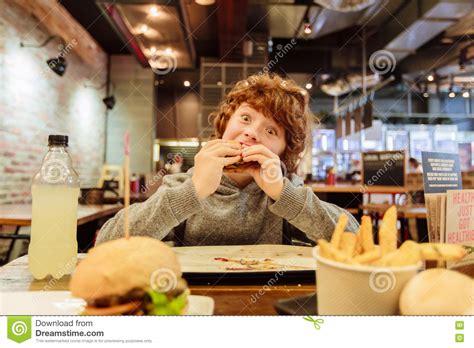 Hungry Boy Eats Burger In Restaurant Stock Photo - Image of food ...