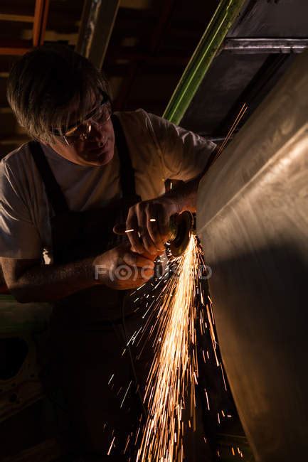 Male Mechanic Using Grinder Machine In Garage — Repairman Sparkling