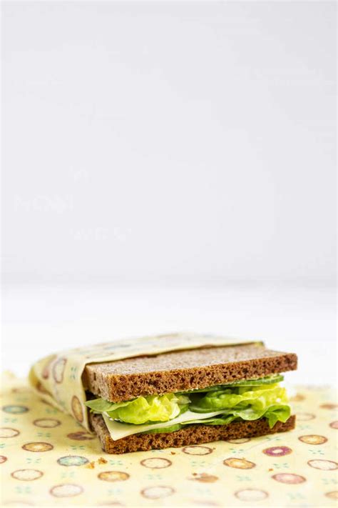 Sandwich Wrapped In Beeswax Cloth In Front Of White Background Stock Photo