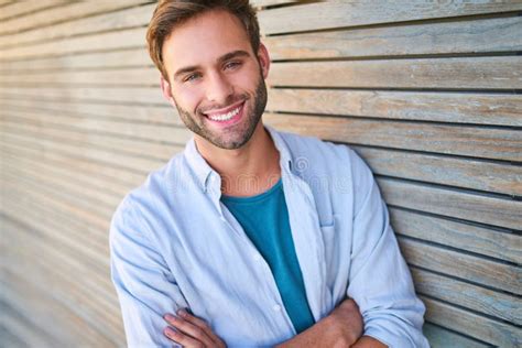 Attractive White Guy Smiling At Camera Leaning Against Wooden Cladding