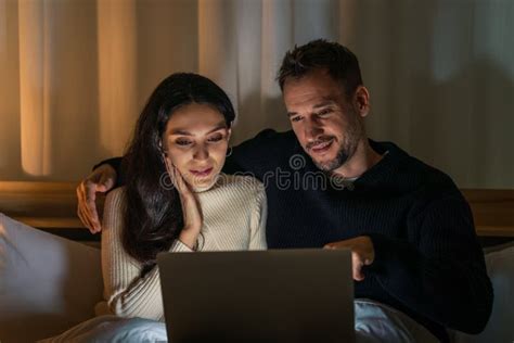 Couple Watching Movie With Laptop Computer Together On Bed Stock Image