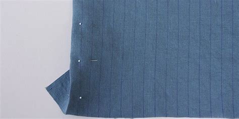 A Piece Of Blue Fabric With Pins Sticking Out Of The Middle On Top Of