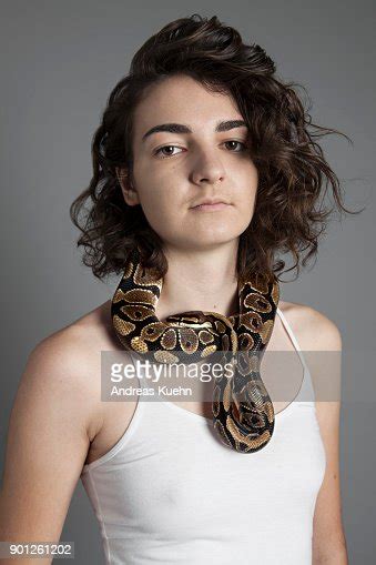Young Woman In Her Late Teens Wearing A White Tank Top In Front Of A