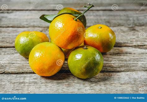 A Lot Of Fresh Mandarin Orange Or Mandarine With Green Leafs On Wooden