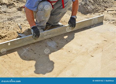 Worker Screeding Sand Bedding To Level For Laying Paving Slabs Stock