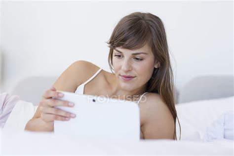 Young Woman Lying On Bed And Using Digital Tablet — Technology Leisure