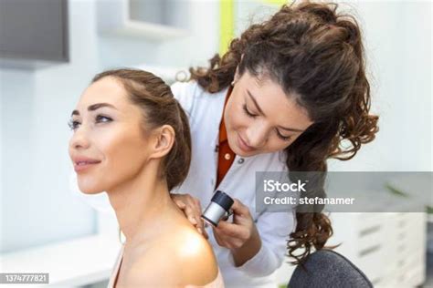 Female Dermatologist Carefully Examining The Skin Of A Female Patient