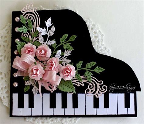 A Black And White Piano With Pink Flowers On Its Side Next To Lace Doily