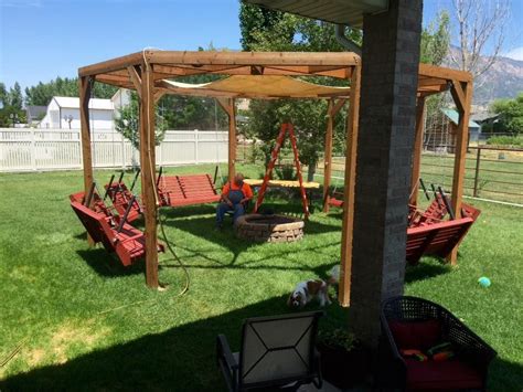 Hanging swings around fire pit how to build swing set. DIY round pergola with swings, firepit and shade screen ...