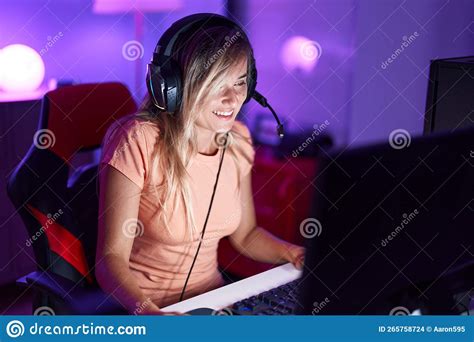 Young Blonde Woman Streamer Playing Video Game Using Computer At Gaming