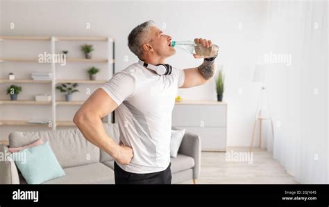 Stay Hydrated Mature Man Drinking Water During Home Workout Standing