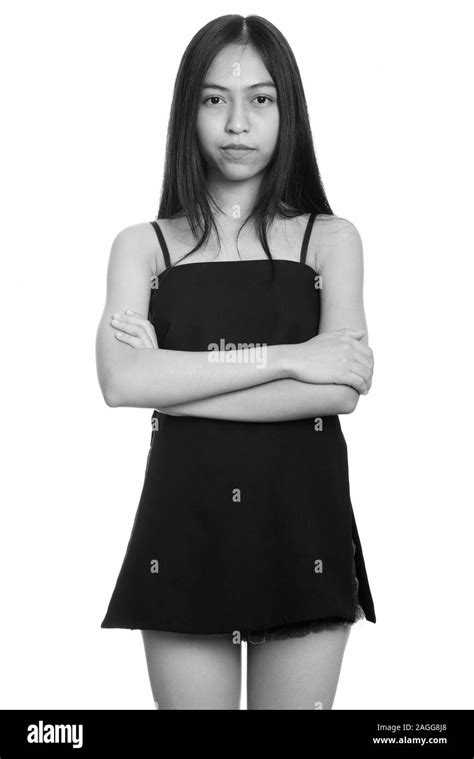 Studio Shot Of Young Asian Teenage Girl Standing With Arms Crossed