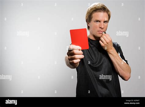 Referee Holding Red Card And Blowing Whistle Stock Photo Alamy