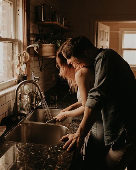 A Man And Woman Washing Their Hands In The Kitchen Sink