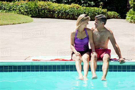 Caucasian Couple Sitting Near Swimming Pool Stock Photo Dissolve