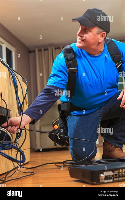 Cable Installer Working In A Home Behind The Tv Stock Photo Alamy