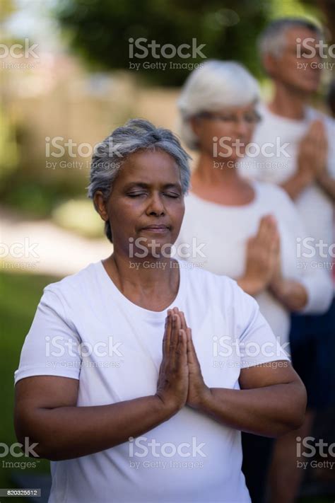 Senior People Meditating With Closed Eyes In Prayer Position Stock