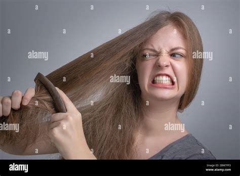 Young Caucasian Woman Girl Struggling To Comb Brush Her Straight Hair With Funny Frustrated Face