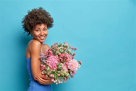 Free Photo Sideways Shot Of Young Woman Wears Dress Holds Bouquet Of