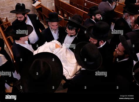An Ultra Orthodox Jewish Father Holds Newly Circumcised Baby Son During
