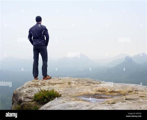 Nature Hiker On Sharp Cliff Roc Watching Over Misty Valley To Blurred Horizon Terrible Rainy