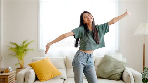 Young Asian Woman Dancing On The Floor In Living Room At Home Stock