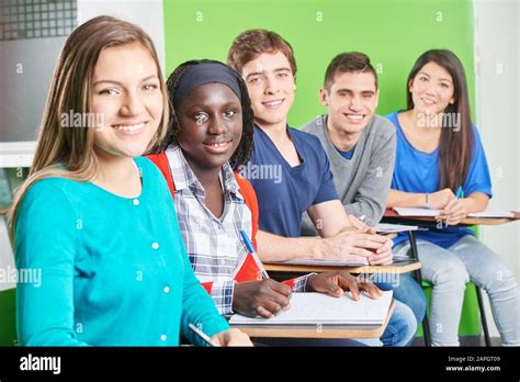 Multicultural Group Of Students Sitting Smiling At School Stock Photo