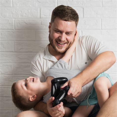 Pai e filho em casa jogando jogos digitais Foto Grátis